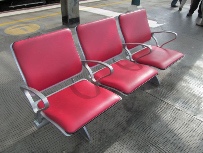 Most stations in Britain have hard seats (as do some trains and trams). Sometimes there are comfortable seats in waiting rooms. At Carlisle station there are padded seats on the platform itself. This is extremely rare. However, Carlisle does benefit from a station roof that covers all of the platforms and tracks