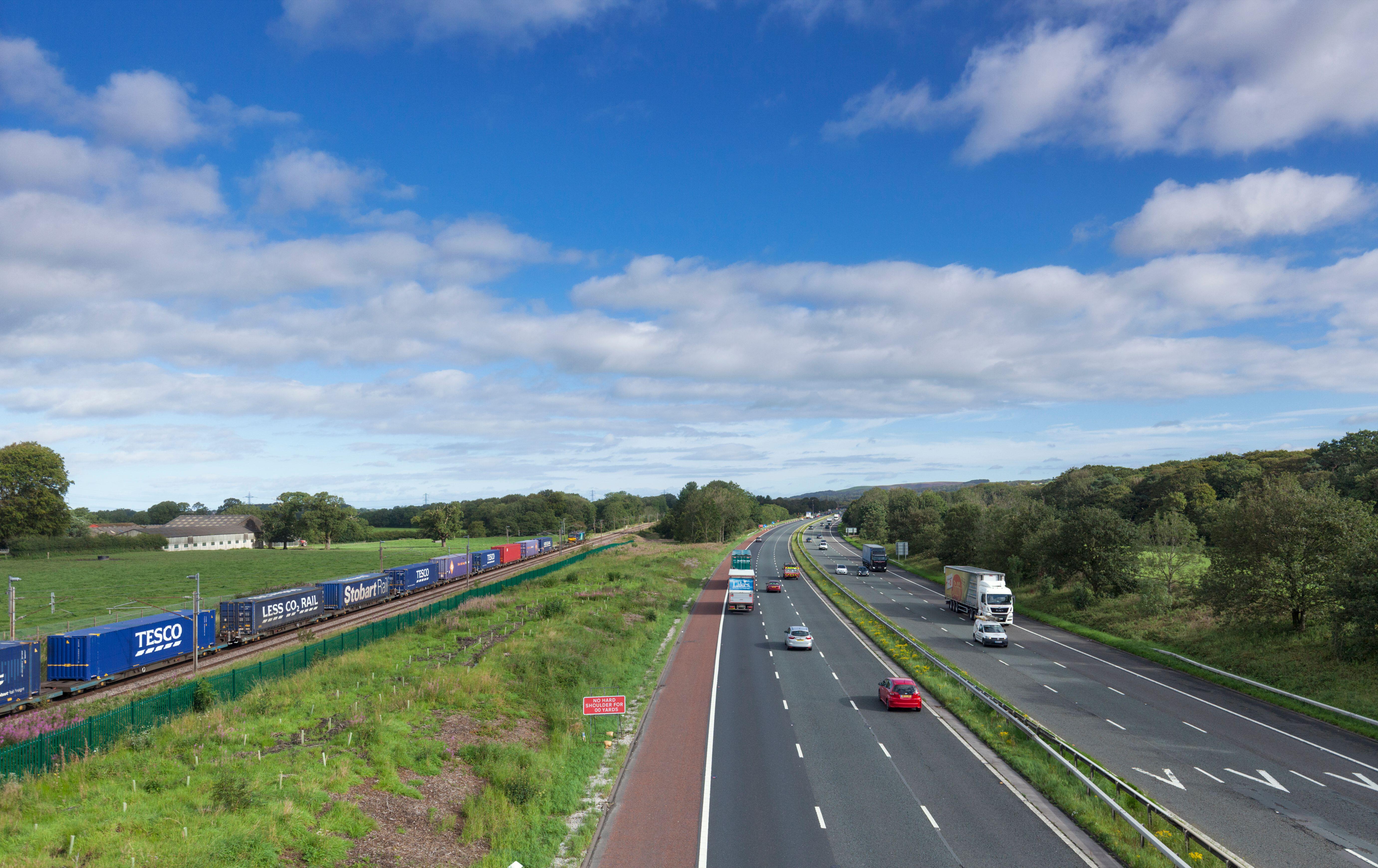 
24/08/2020 Brock (north of Preston) DRS class 88 locomotive 88002 running alongside the M6 motorway with train 4S43 the 0624 Daventry to Mossend Tesco intermodal container train.  Photo by Robert Lancaster licensed via Alamy purchased 23/08/2025 by chris.page@railfuture.org.uk